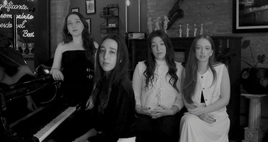 As irmãs reunidas em volta de um piano de cauda