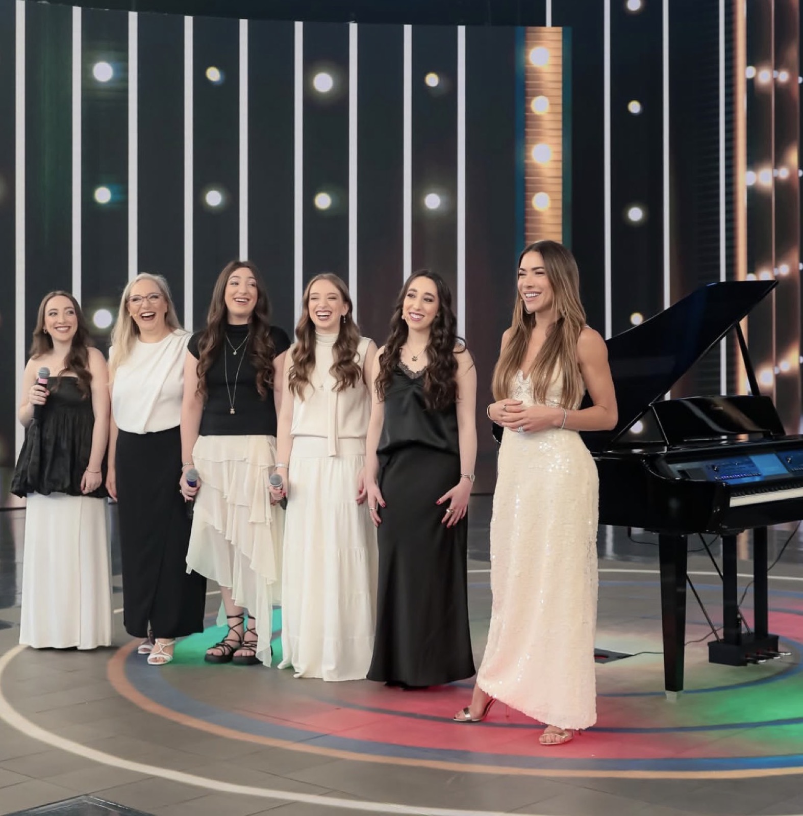 As irmãs no palco do Programa Silvio Santos, ao lado de um piano de cauda